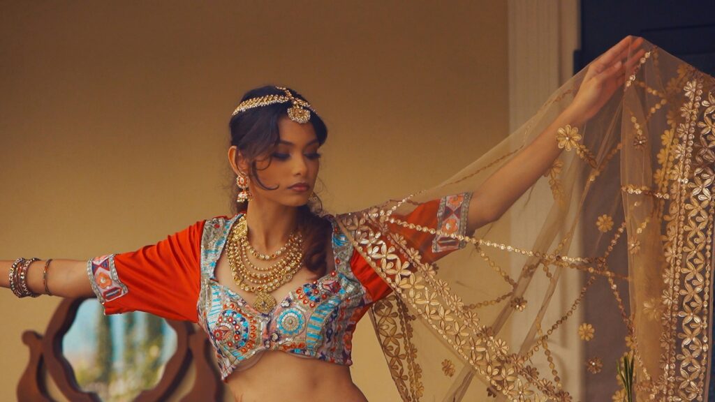 image shows a bollywood actress dancing for a bollywood murder mystery game