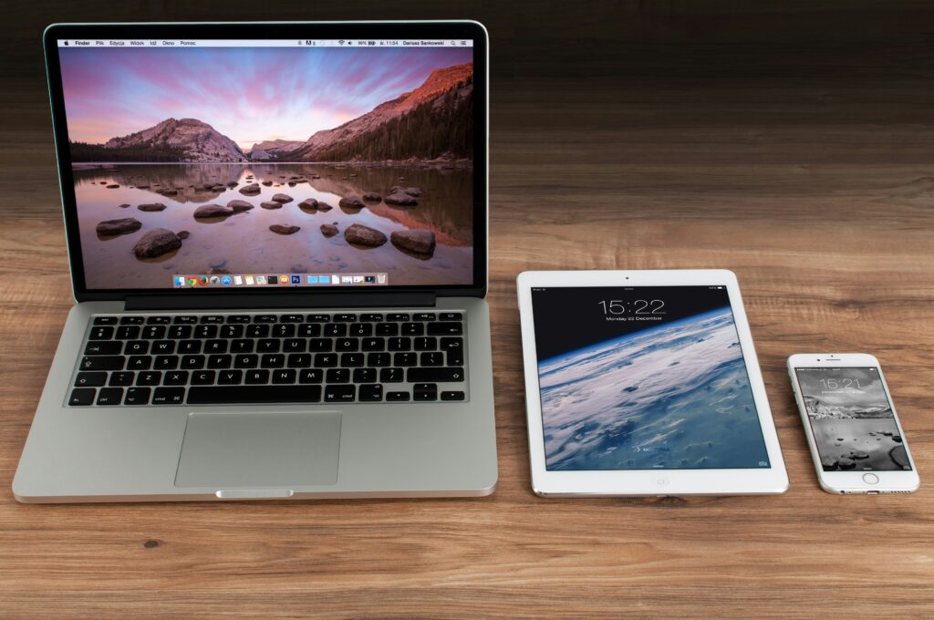 This image shows a laptop tablet and mobile phone for downloading murder mystery games